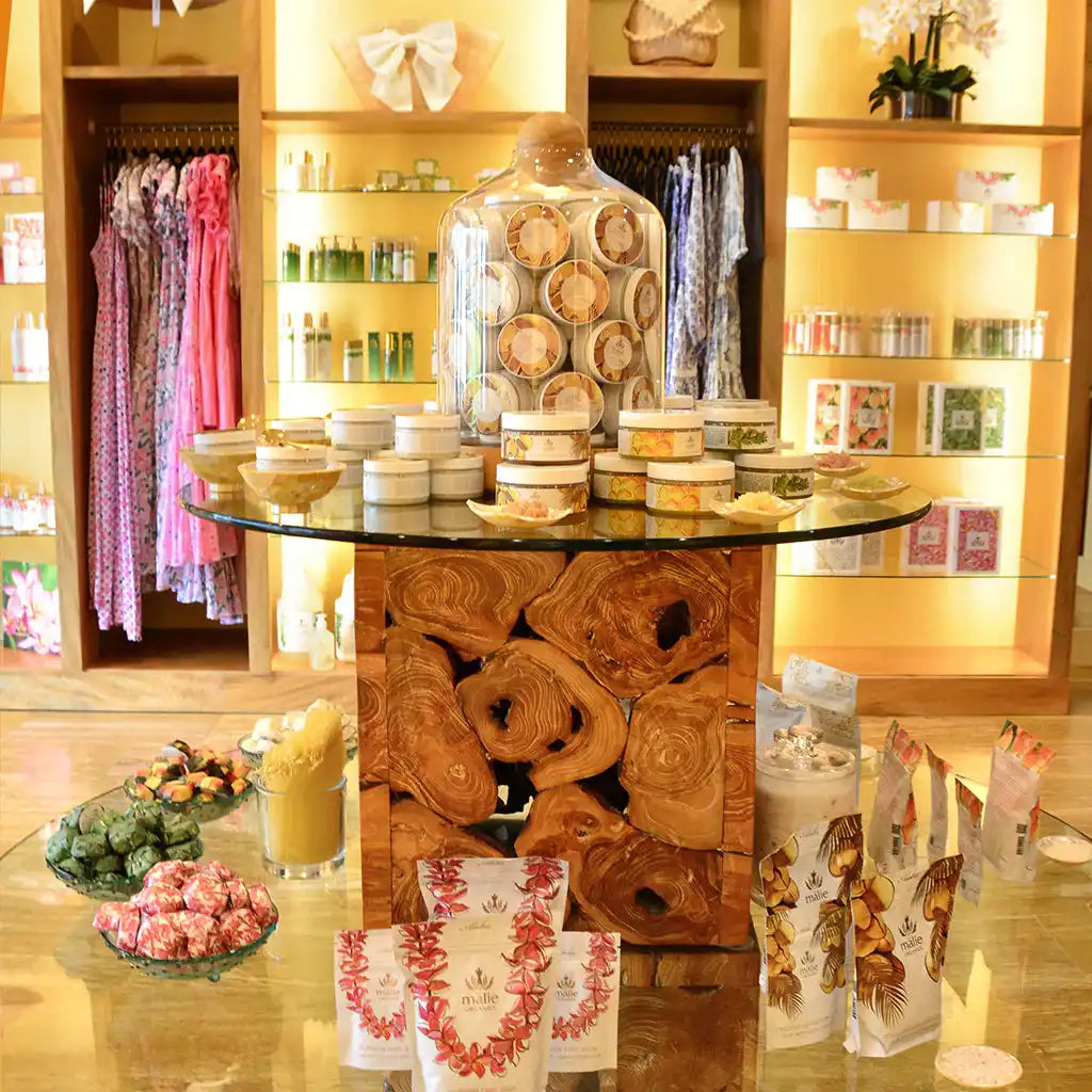 A circular glass table with an ornately carved wooden base featuring floral or rose patterns.