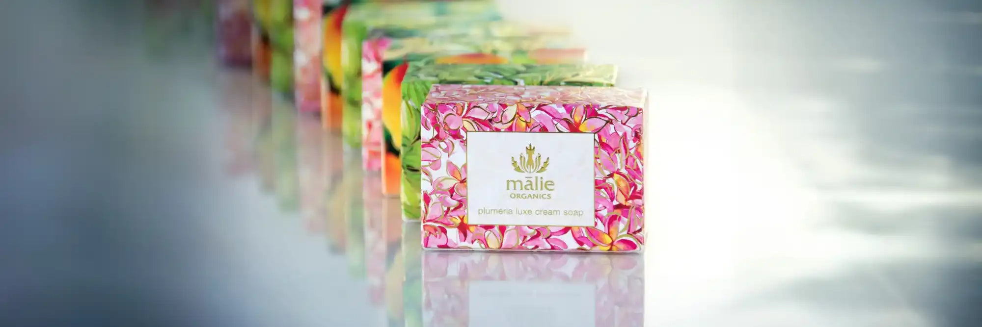 Pink floral patterned box with a white label and gold crown logo.