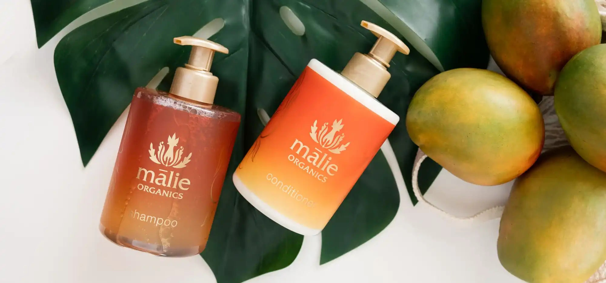 Two orange-tinted Malie Organics shampoo bottles with pump dispensers.